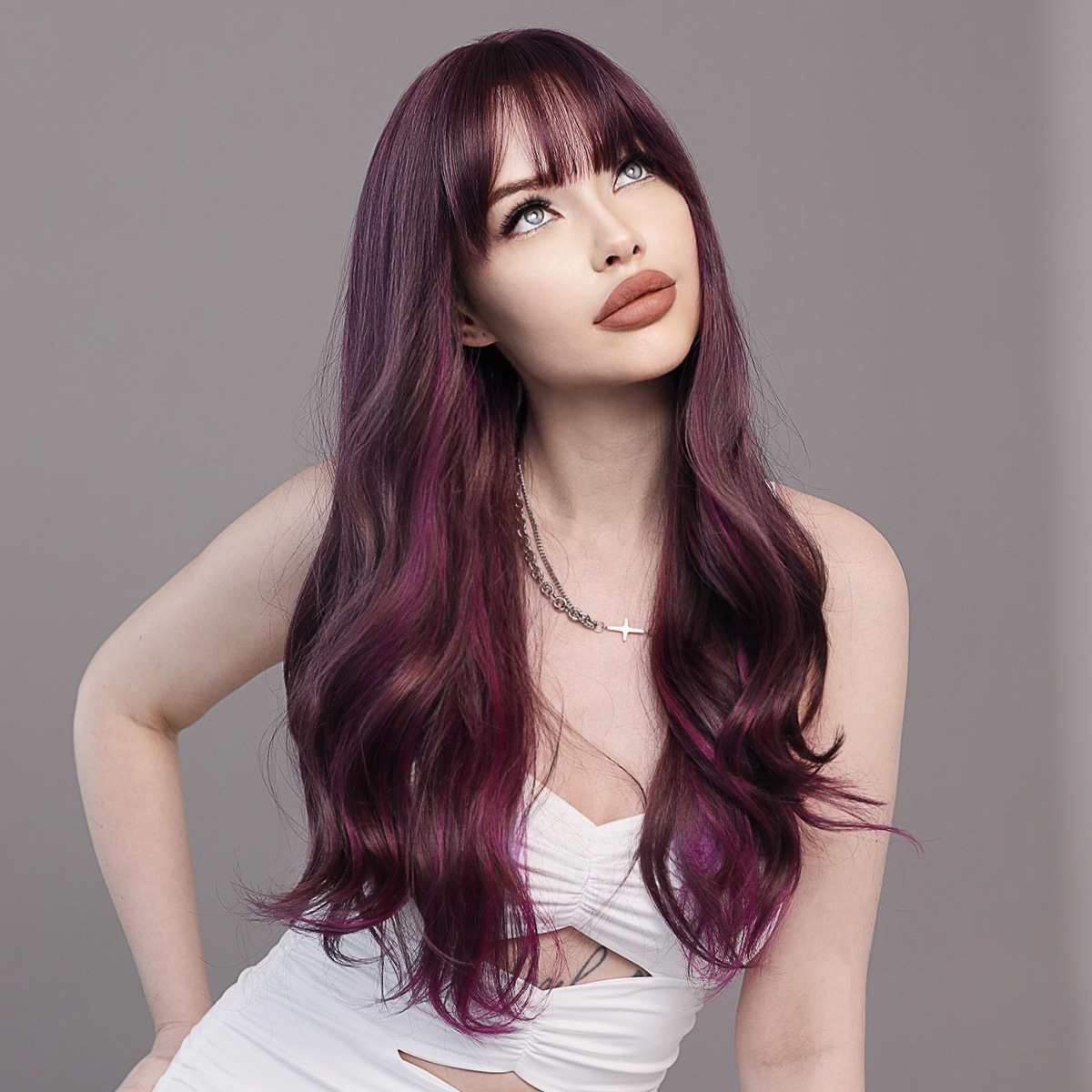 A synthetic wig in purple brown with long wavy hair and bangs, ready to go