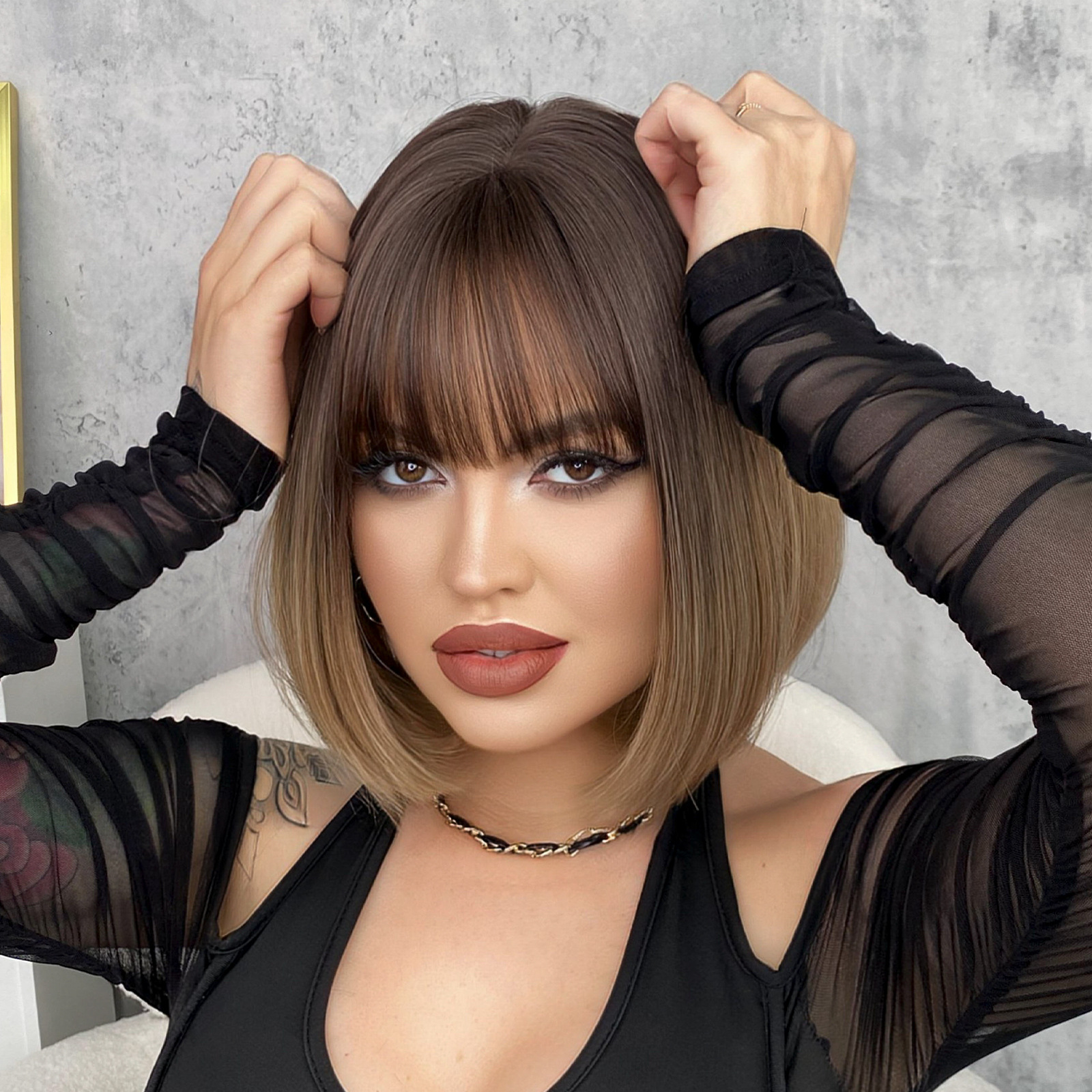 A fashionable female wig with short hair in a BOB head style, made from synthetic material with a gradient color and bangs for a trendy appearance