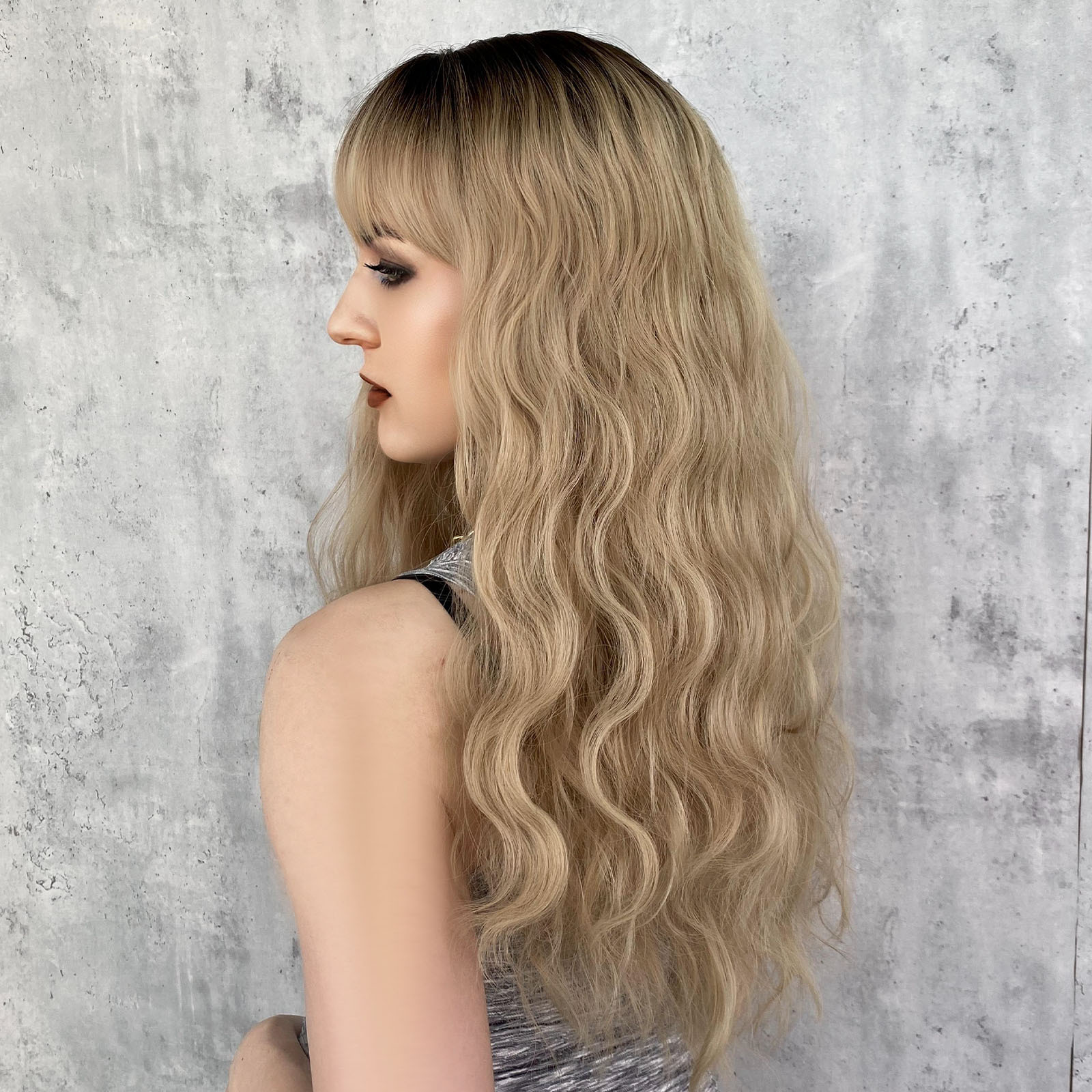 A fashionable synthetic wig for women, featuring long wavy blonde hair set on a rose net, ready for immediate use